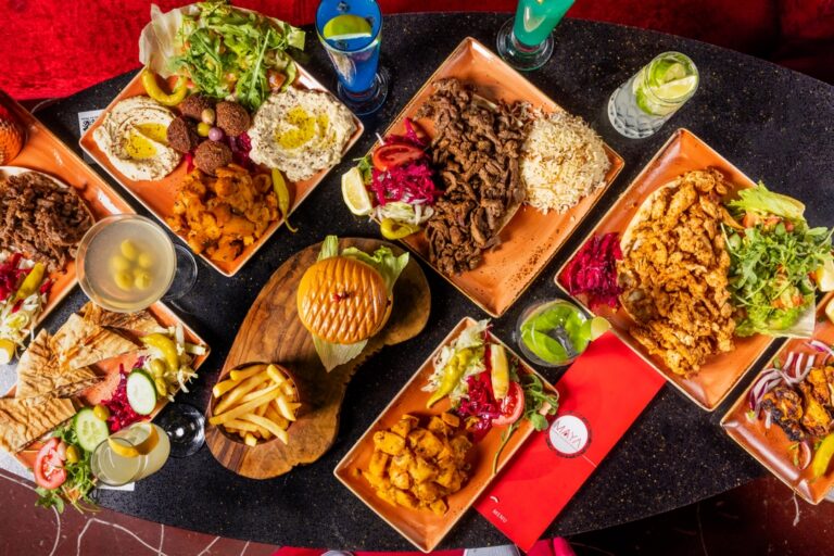 Overhead spread of mixed grills, fries, salads and drinks at Maya Lounge, a shisha lounge near Cockfosters