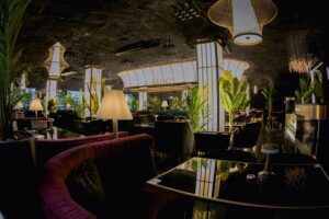 Elegant velvet booth seating and plants inside Maya Lounge