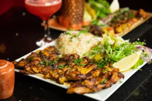 Grilled chicken skewers with rice, salad and cocktail at Maya Lounge