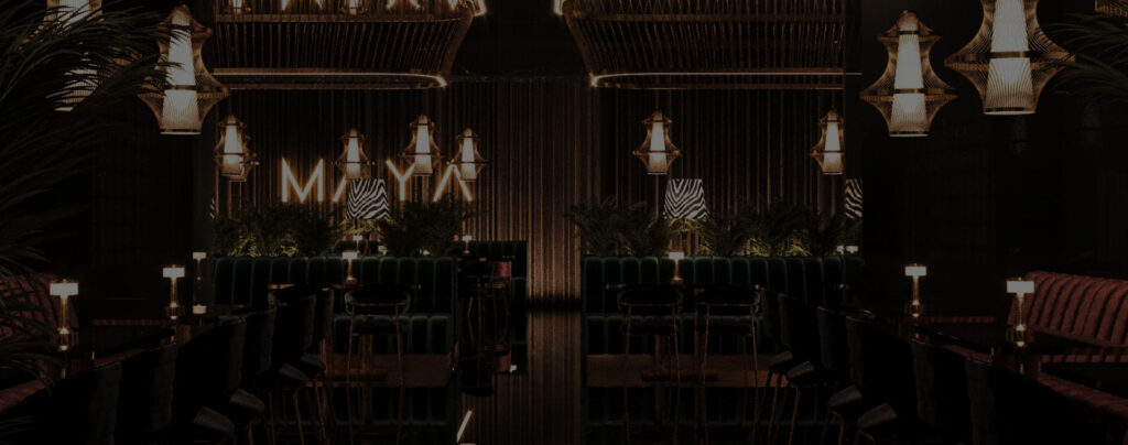 Wide view of the Maya Lounge interior with illuminated MAYA sign and seating